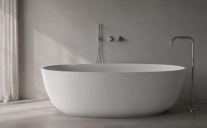 Freestanding oval tub with wall-mounted and floor-standing chrome fixtures in a light bathroom